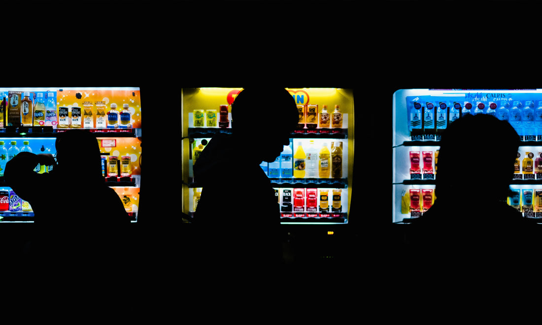 People using a vending machine at night.
