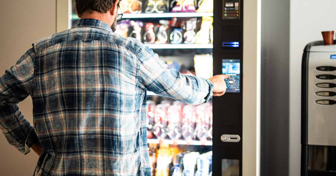 Back view of a man using a vending machine